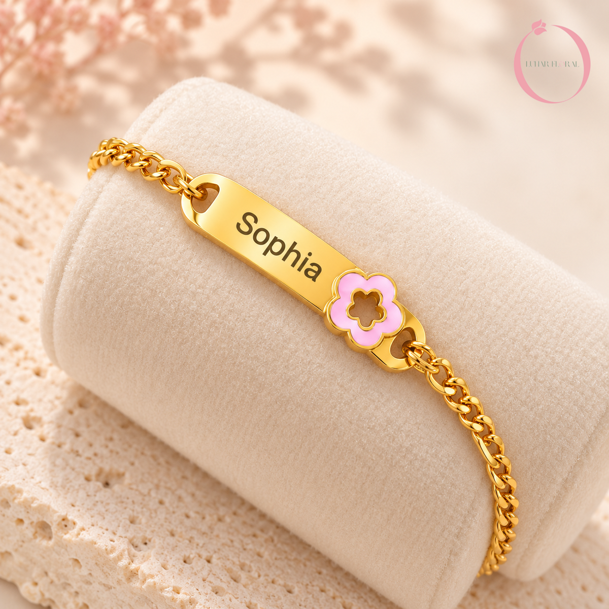 Close-up of personalized gold baby bracelet with pink enamel flower - Lunar Floral